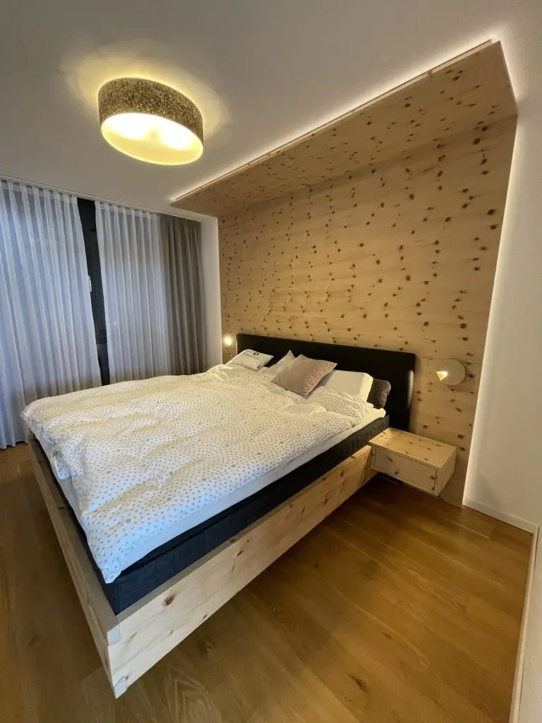 Schlafzimmer mit Wand aus Zirbe